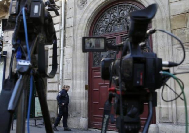 A police officer stands guard at the entrance of a luxury residence on the Rue Tronchet in Paris
